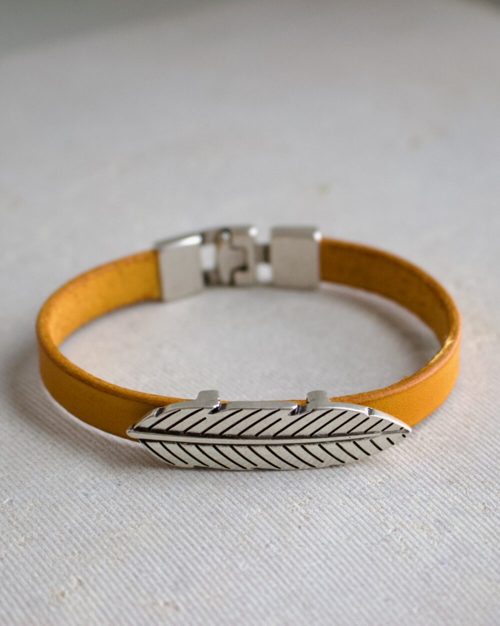 Bracelet marron en cuir avec design plume et fermoir métallique